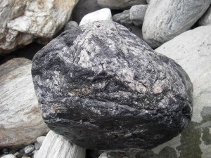 玫瑰石的原礦,不要看它黑黑的,因含有錳的成分,切開後會成粉紅色不過因為容易氧化,如果沒有加工處理,又會變得黑黑的了達人說這一粒就價值上萬喔!
